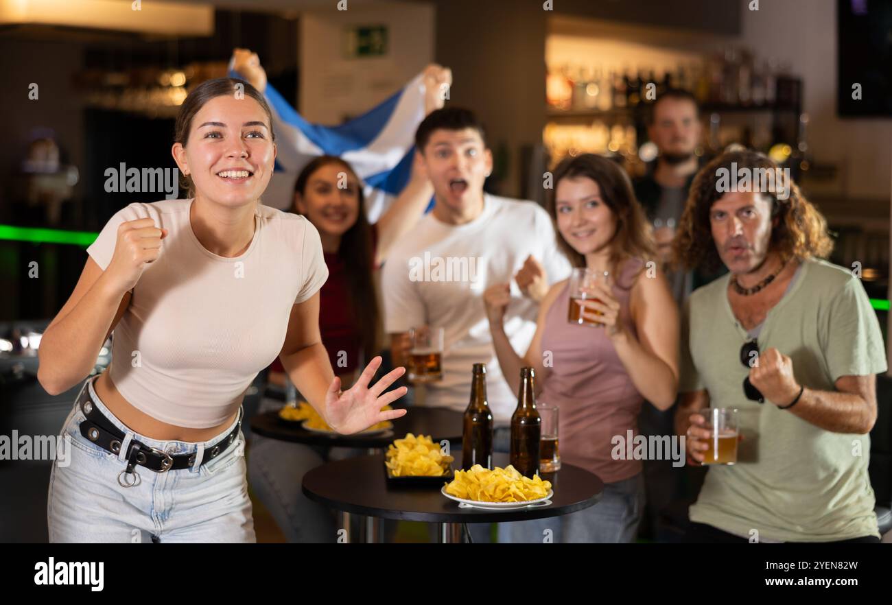 Gruppo di fan al bar con bandiera scozzese Foto Stock