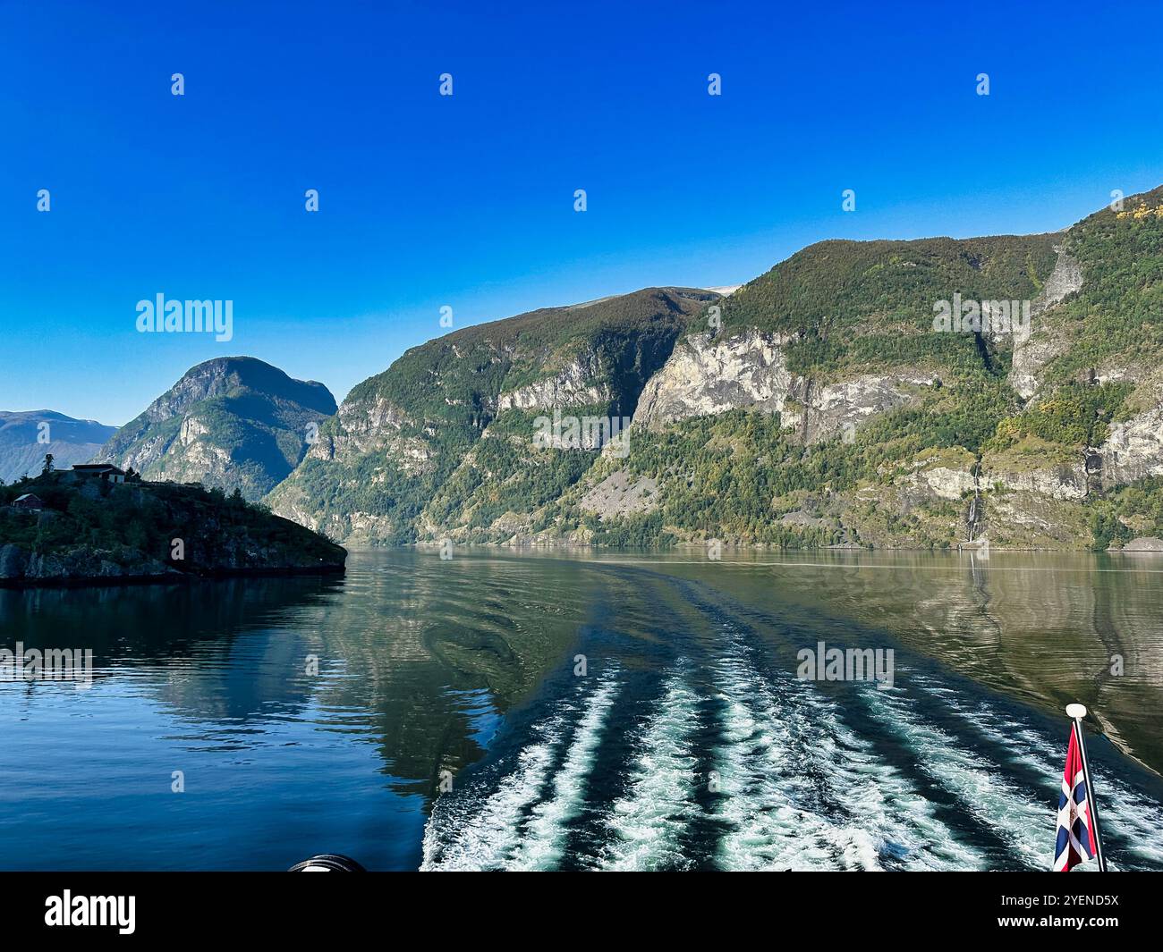 Flam, Norvegia, settembre 2024, le luci del mattino si aprono sul Aurlandfjord, come si vede dal ponte posteriore della nave turistica elettrica - il Foto Stock