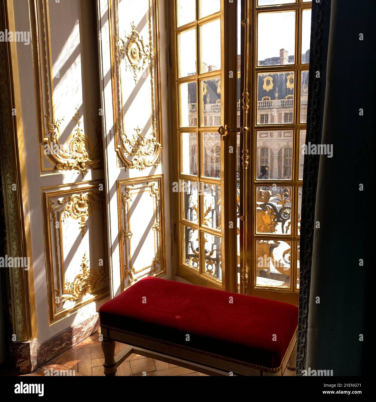 Moody Interior a Versailles: Panca in velluto vintage, modanature dorate e Ombre illuminate dal sole - Immagine stock catturata con smartphone