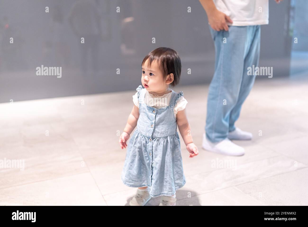 Una ragazza taiwanese di un anno che passa del tempo con i suoi genitori, un uomo e una donna di vent'anni, vicino all'ingresso di un alto appartamento nella città di Taichung, Foto Stock