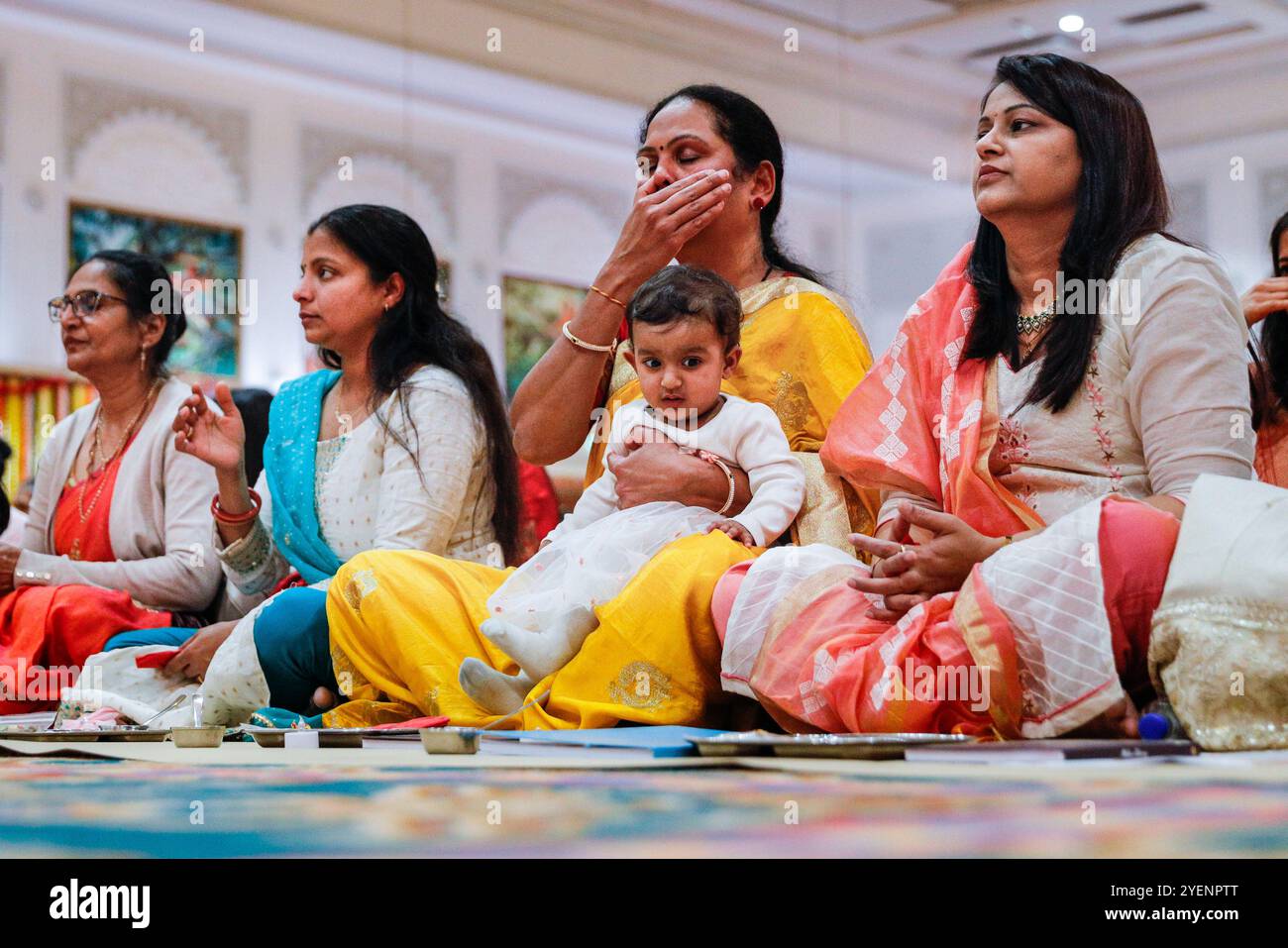 Londra, Regno Unito. 31 ottobre 2024. Devoti alla cerimonia di Sharda Pujan, che rende omaggio a Saraswati devi, la divinità indù della conoscenza, delle arti e della saggezza. Diwali, il Festival indù delle luci, viene celebrato presso il BAPS Shri Swaminarayan Mandir, popolarmente conosciuto come il Tempio Neasden, con un festival gratuito di cerimonie tradizionali, culto e attività familiari. Crediti: Imageplotter/Alamy Live News Foto Stock