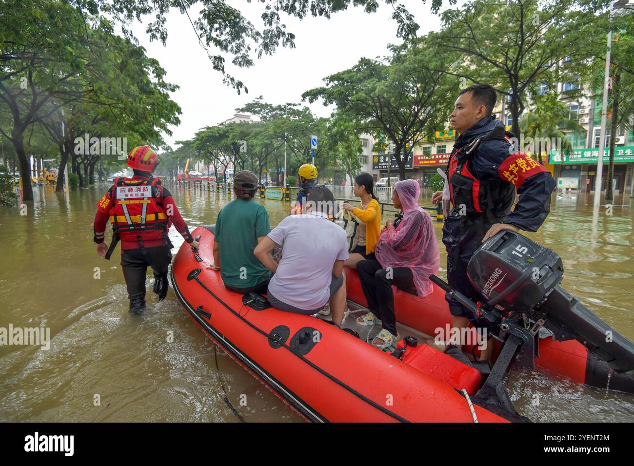 Il personale di soccorso evacua le persone dalle aree pericolose nella città di Qionghai, provincia di Hainan, il 30 ottobre 2024. Haikou, Cina.30 ottobre 2024. I resti del tifone Trami insieme a una massa d'aria fredda hanno innescato gravi inondazioni a Hainan, la provincia insulare più meridionale del paese. Il Ministero delle risorse idriche cinese ha emesso una risposta di emergenza di livello IV alle inondazioni a causa dell'impatto persistente del tifone Trami ad Hainan, il 30 ottobre 2024. Colpite dal tifone Trami, la maggior parte delle aree di Hainan subirà piogge torrenziali, con un alto rischio di inondazioni improvvise, e il fiume Wanquan potrebbe subire inondazioni Foto Stock