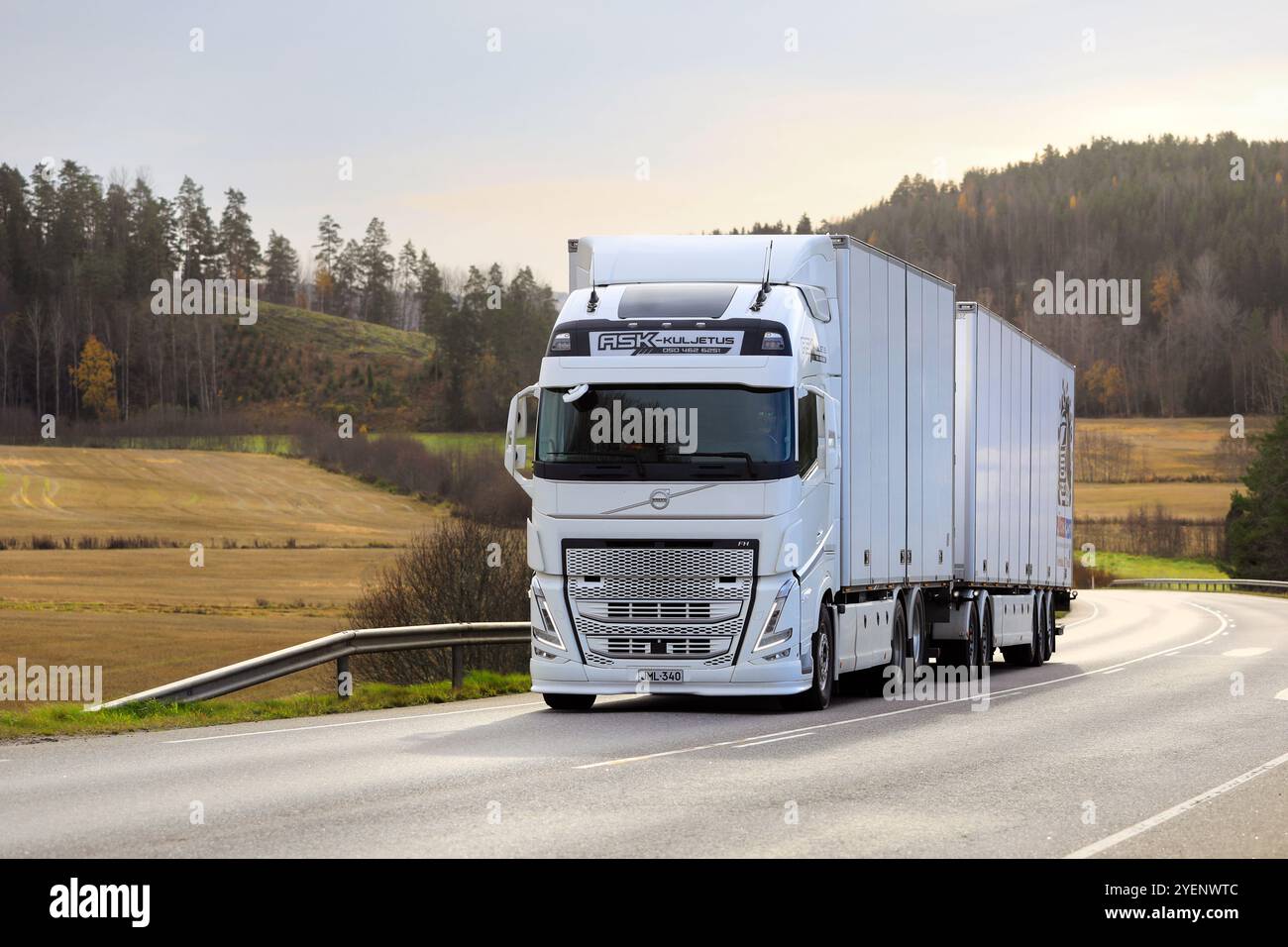 Il nuovo Volvo FH bianco trasporta un rimorchio merci in salita sull'autostrada 52 nella luce dorata del tardo autunno. Copia spazio. Salo, Finlandia. 24 ottobre 2024. Foto Stock