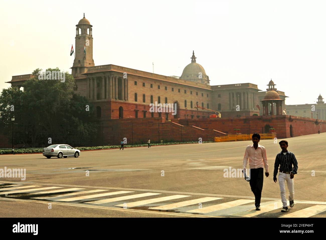 Persone che camminano sul viale Rajpath sullo sfondo dell'edificio della segreteria indiana sulla collina di Raisina a nuova Delhi, Delhi, India. Foto Stock