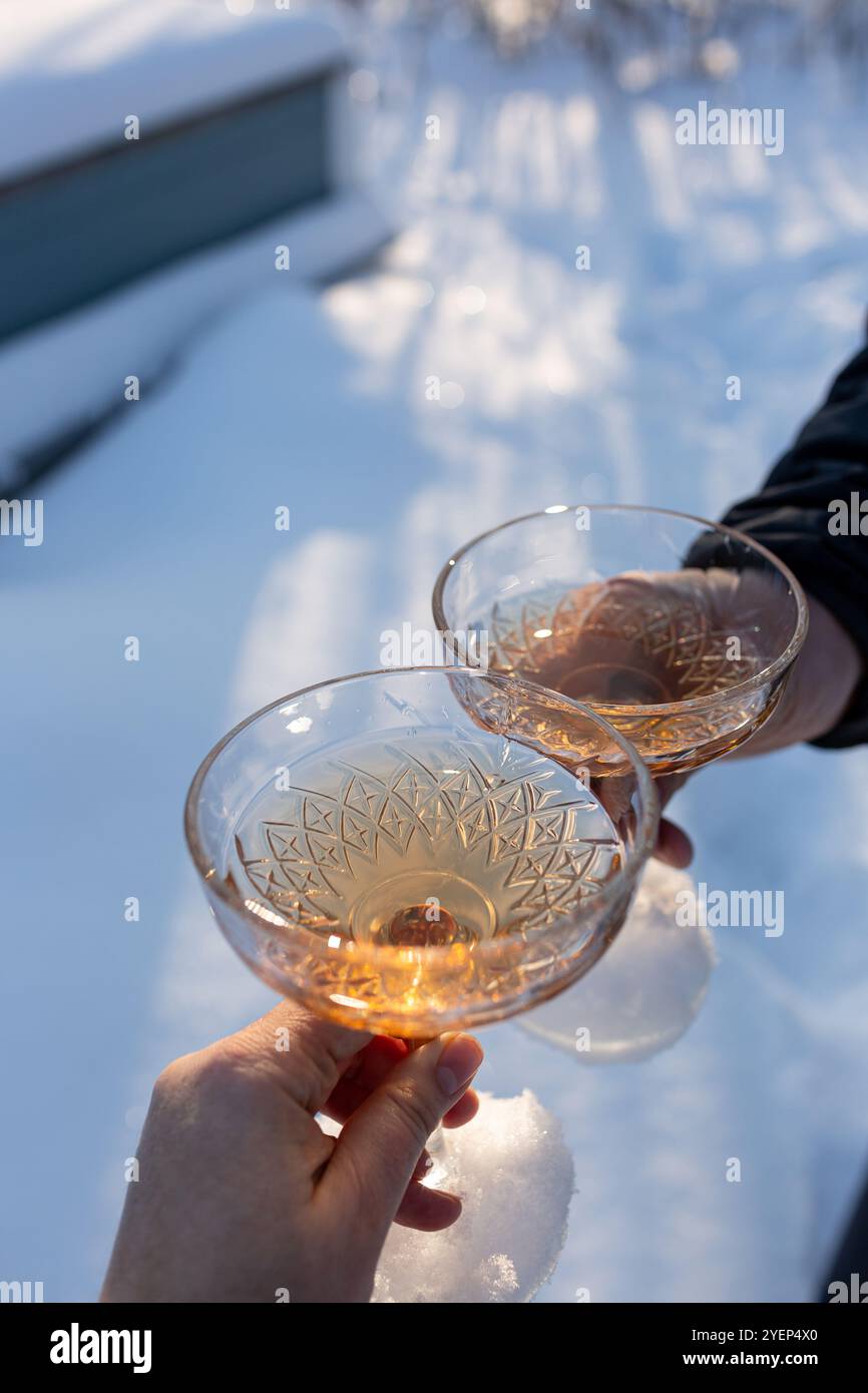 Un uomo e una donna con bicchieri di champagne sullo sfondo della neve. Concetto di vacanza, Natale e Capodanno, storia d'amore romantica, stagione delle feste Foto Stock