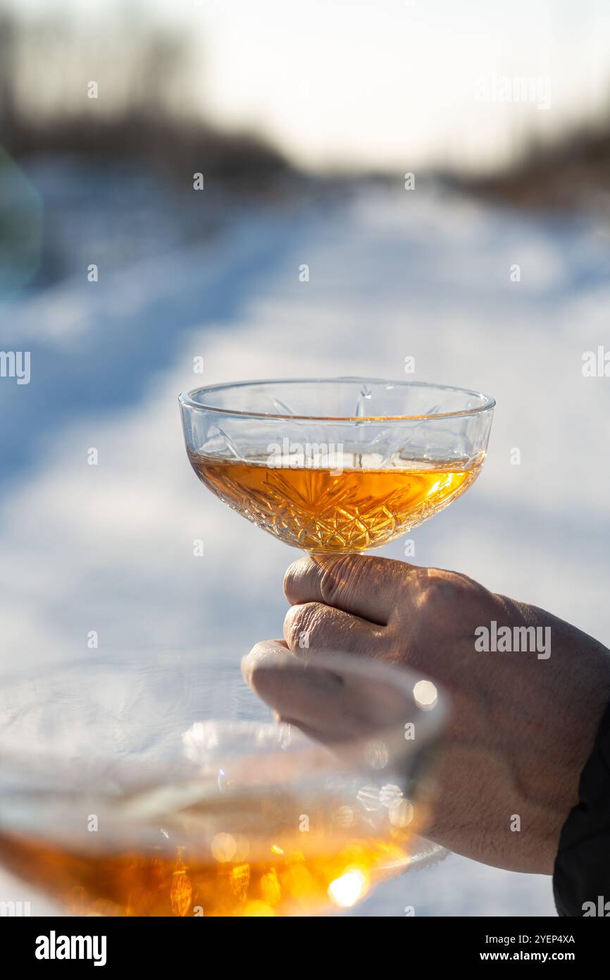 Un uomo e una donna con bicchieri di champagne sullo sfondo della neve. Concetto di vacanza, Natale e Capodanno, storia d'amore romantica, stagione delle feste Foto Stock