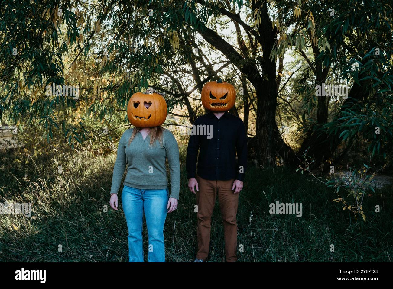 Una coppia che indossa le zucche intagliate sulla testa Foto Stock