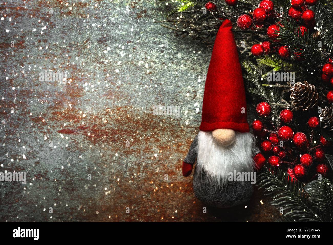 Sfondo del concept natalizio. Vista dall'alto dello gnomo natalizio con rami di bacche rosse, fiocchi di neve e spazio per testo su sfondo astratto Foto Stock