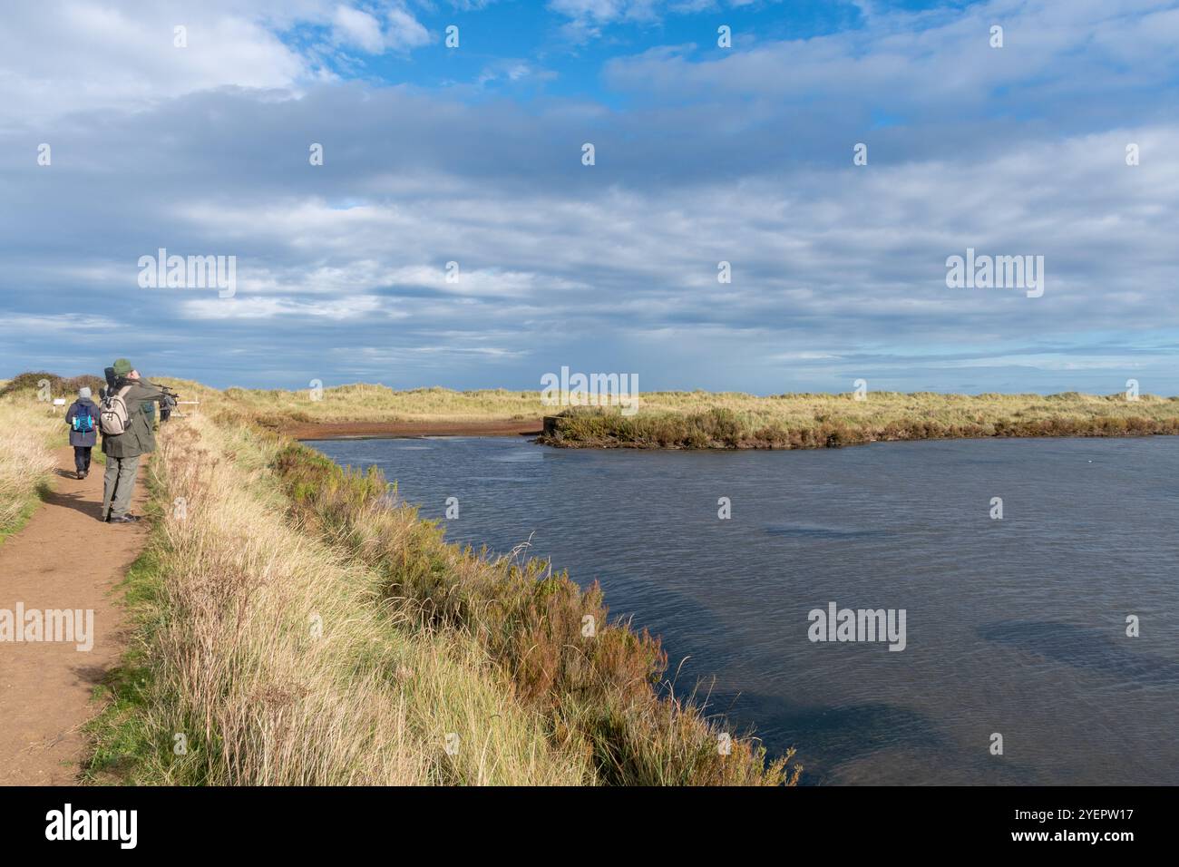 Vista della riserva naturale RSPB Titchwell Marsh nel North Norfolk, Inghilterra, Regno Unito, con un gruppo di birdwatching in autunno Foto Stock
