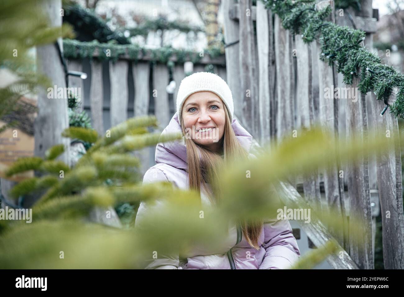 Donna in giacca invernale immersa nel verde seduta su scale rustiche Foto Stock