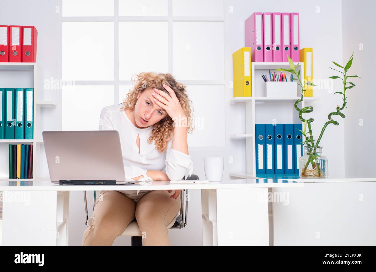 Lavoratore in ufficio femmina sotto stress. Donna stanca e confusa. Stanco lavoratore d'ufficio. Donna che annoia in ufficio. Foto Stock