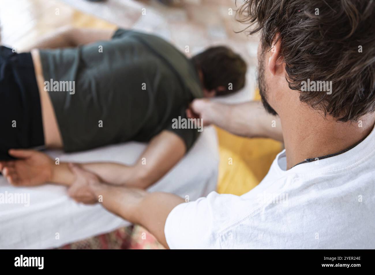 Fisioterapista che fa il massaggio. Osteopatia e concetti di riabilitazione delle lesioni sportive. Messa a fuoco selettiva. Vista dall'alto Foto Stock