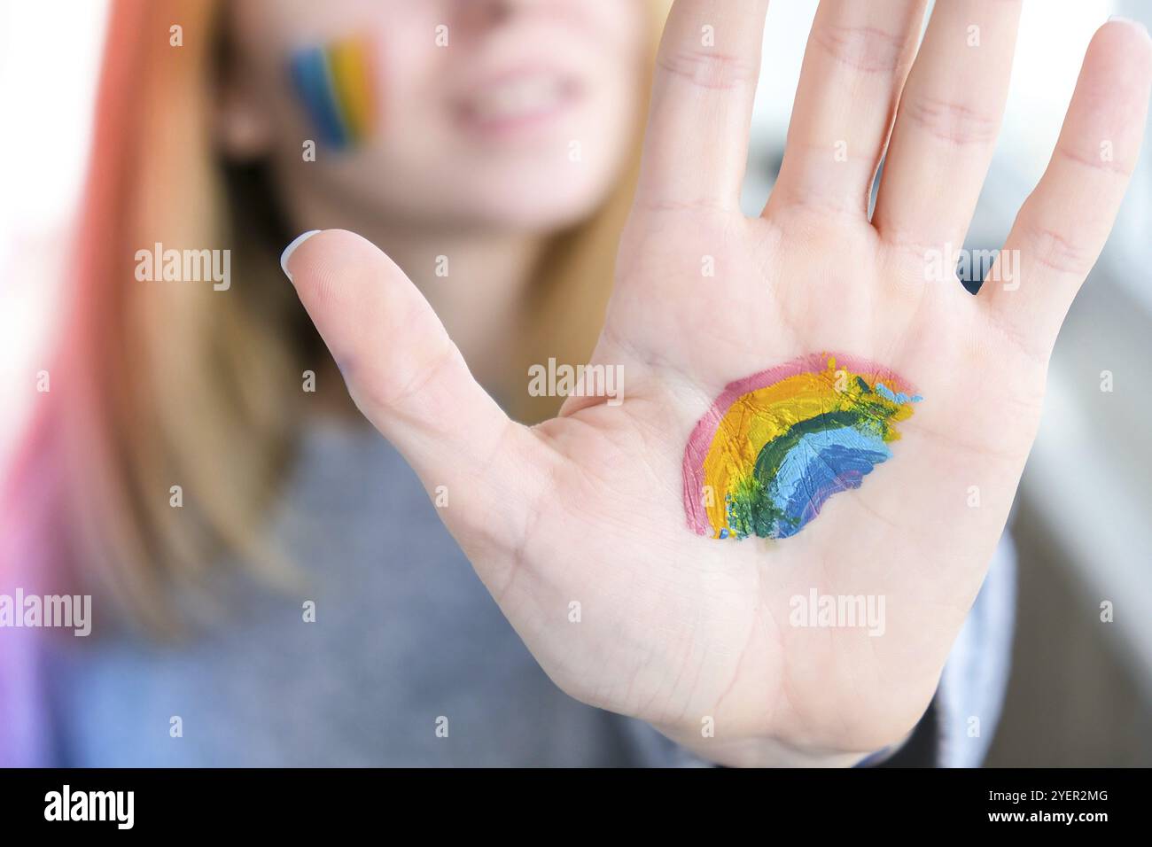 Bandiera Rainbow LGBTQ dipinta a mano e guancia. Supporto per la comunità lgbt. Onore del mese dell'orgoglio. Collegare le persone, toccare le mani. Mano multicolore Foto Stock