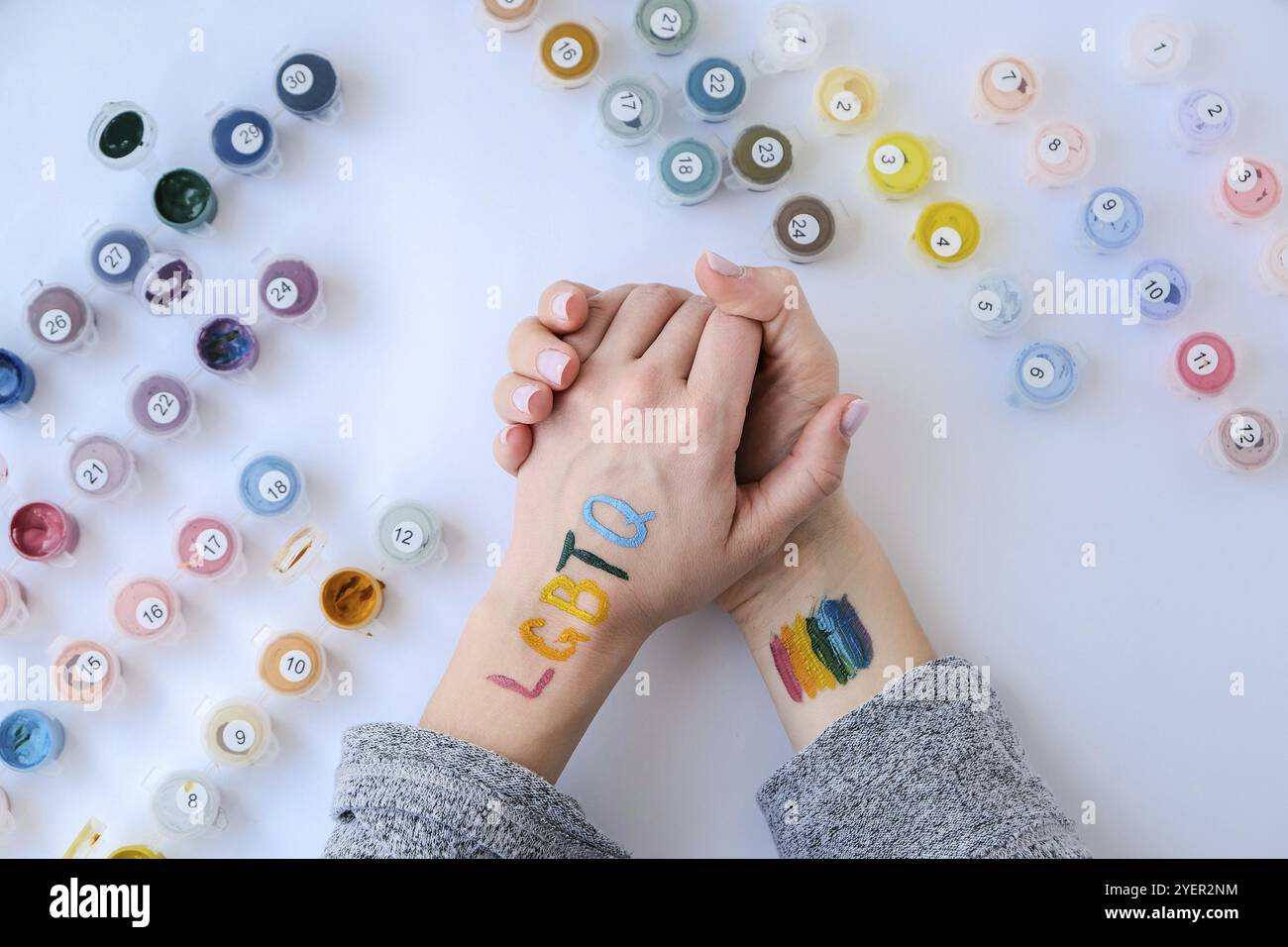 Bandiera Rainbow LGBTQ dipinta a mano. Supporto per la comunità lgbt. Onore del mese dell'orgoglio. Collegare le persone, toccare le mani. Crema mani multicolore Foto Stock