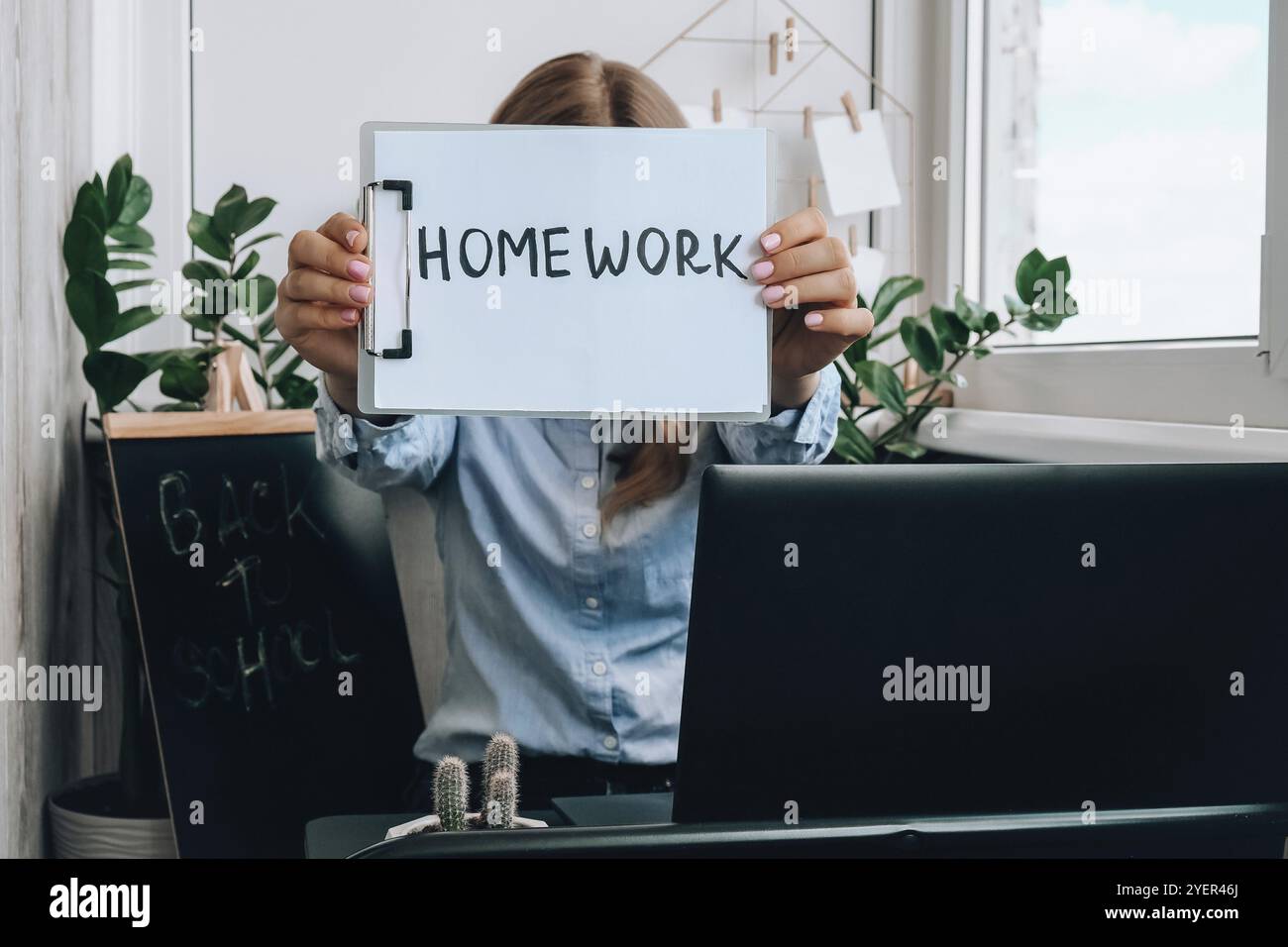 Insegnante giovane femminile seduto alla scrivania e utilizzando il computer portatile che mostra IL testo DEI COMPITI a casa. E Education Torna a scuola. Corso online di apprendimento degli studenti. Distan Foto Stock