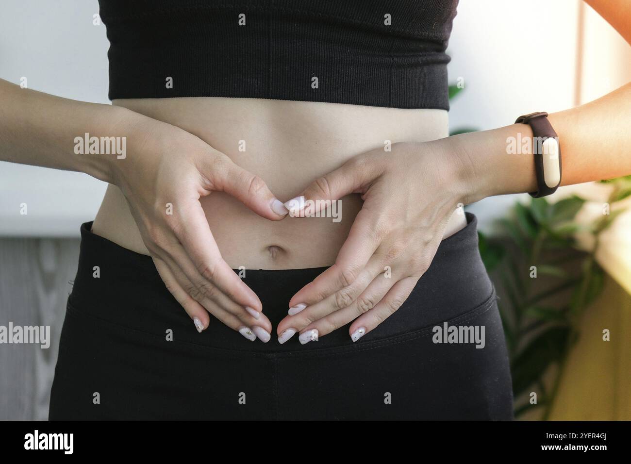 Mano nel cuore simbolo su misura e sottile ventre donna. Concetto di benessere fitness. Cura del corpo, gravidanza, perdita di peso dieta concetto. Donna con viscere o riproduzioni Foto Stock