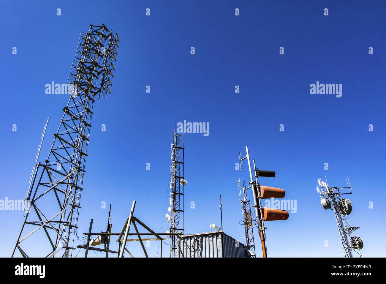 Un basso angolo di visione della radio GPS reticolo di comunicazione di torri di acciaio e la rete cellulare stazione base per la trasmissione e la ricezione di segnali di diffusione Foto Stock