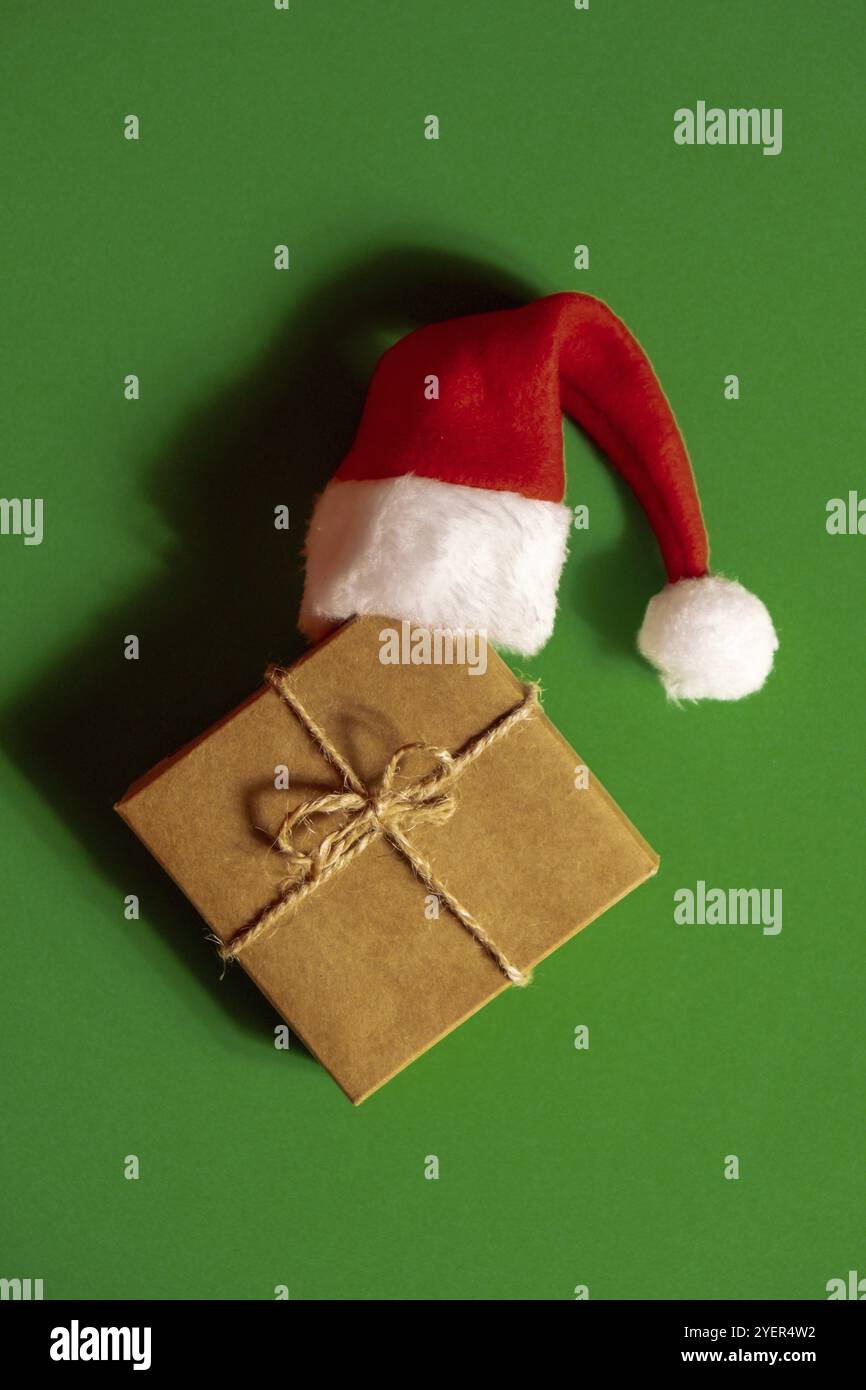 Babbo Natale su scatola regalo di carta presente su sfondo verde. Copiare lo spazio per il testo. Mock up per la pubblicità. Composizione di Natale di festa. Minimale Foto Stock