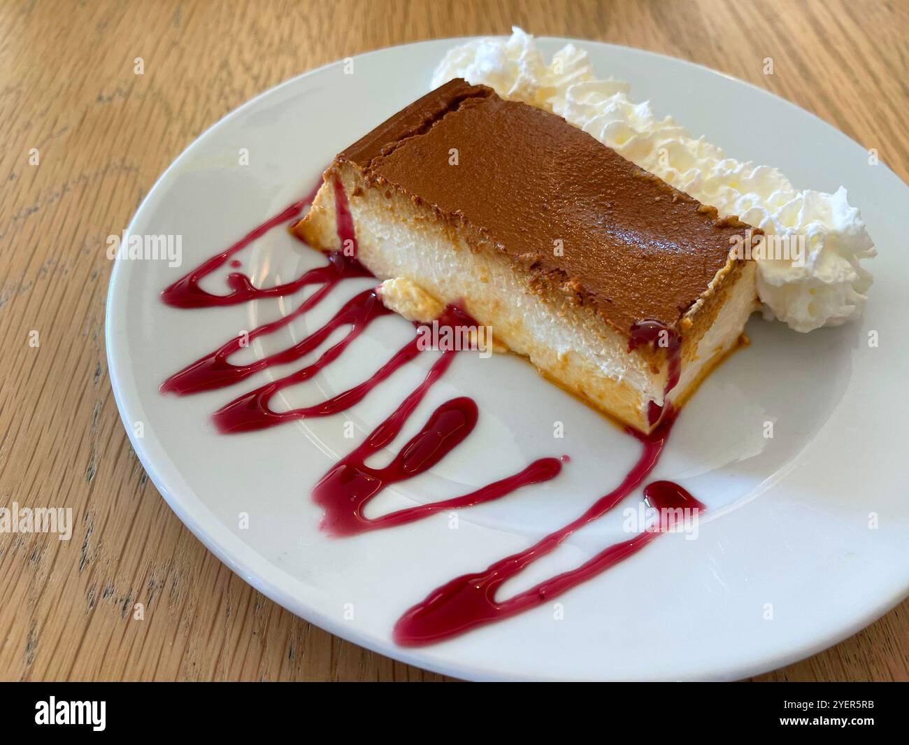 Torta al formaggio con crema e sciroppo di lamponi. Foto Stock