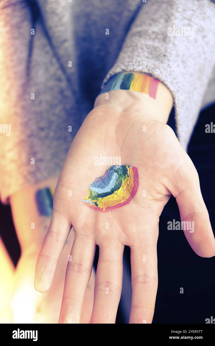 Bandiera Rainbow LGBTQ dipinta a mano. Supporto per la comunità lgbt. Onore del mese dell'orgoglio. Collegare le persone, toccare le mani. Crema mani multicolore Foto Stock