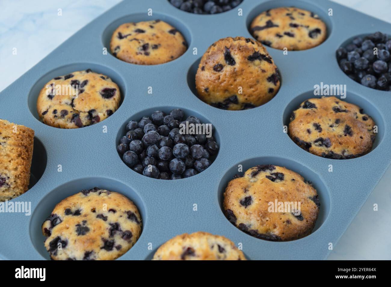 Muffin al mirtillo appena sfornati. Gustoso cupcake dolce. Dolce fatto in casa. Torta di frutti di bosco in muffin di silicone. Cupcake vegani sani con bisturi Foto Stock