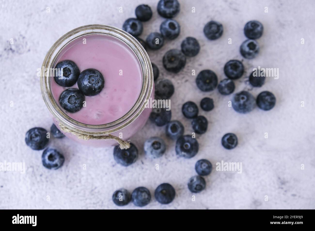 Ciotola con yogurt e mirtilli sul tavolo. Yogurt al mirtillo con mirtilli freschi. Colazione sana. Super cibo sano mangiare vegetariano vegano cibo Foto Stock Ciotola con yogurt e mirtilli sul tavolo. Yogurt al mirtillo con mirtilli freschi. Colazione sana. Super cibo sano mangiare vegetariano vegano cibo Foto Stock