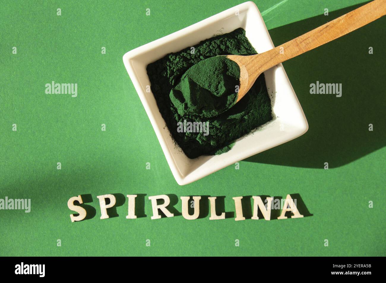 Polvere di spirulina alle alghe blu-verde in ciotola ecologica di bambù con testo SPIRULINA, integratore dietetico per multivitaminici Vegan, Vegetarian o a base vegetale B. Foto Stock