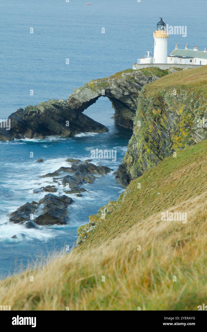 Faro e arco naturale dell'Isola di Bressay, Isole Shetland Foto Stock