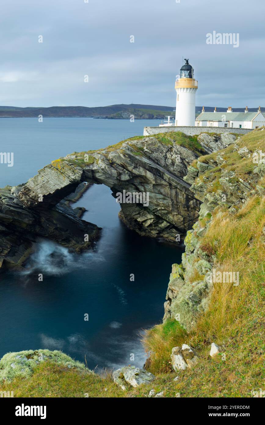 Faro e arco naturale dell'Isola di Bressay, Isole Shetland Foto Stock