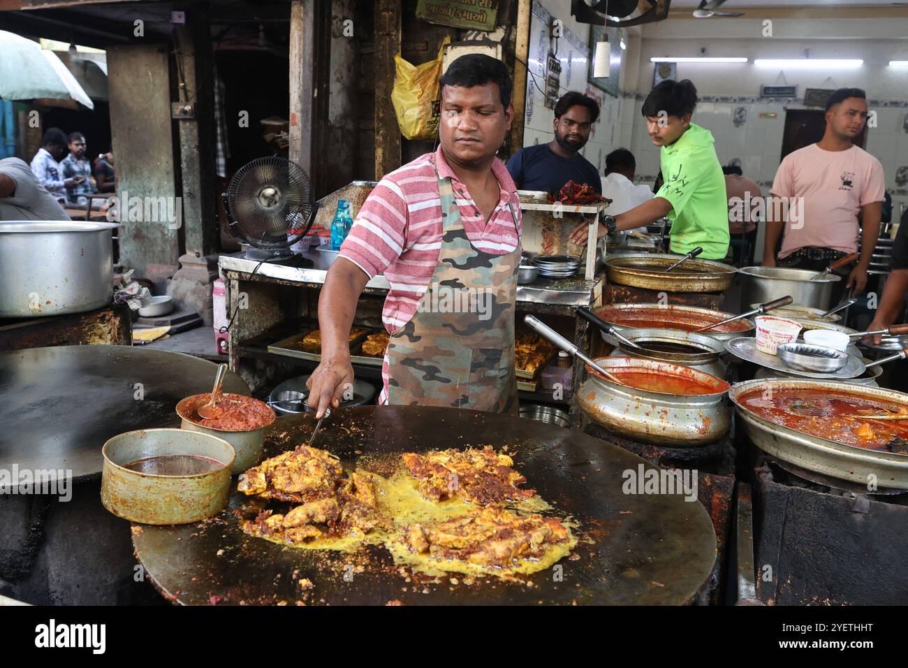 Un venditore che cucina pollo fritto nel mercato Lal Darwaja della città vecchia di Ahmedabad, Gujarat, India Foto Stock