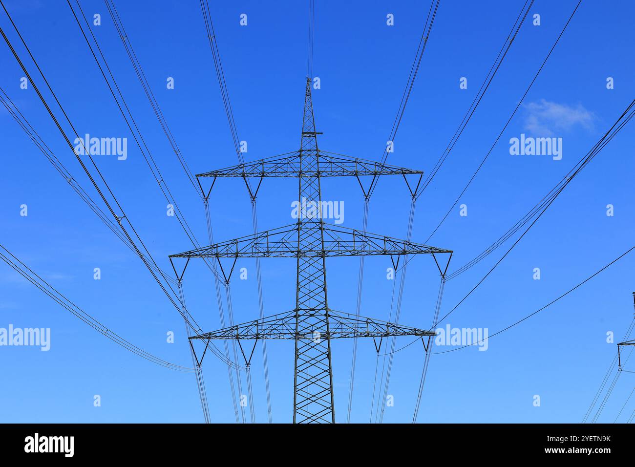 Pilone ad alta tensione contro un cielo blu Foto Stock