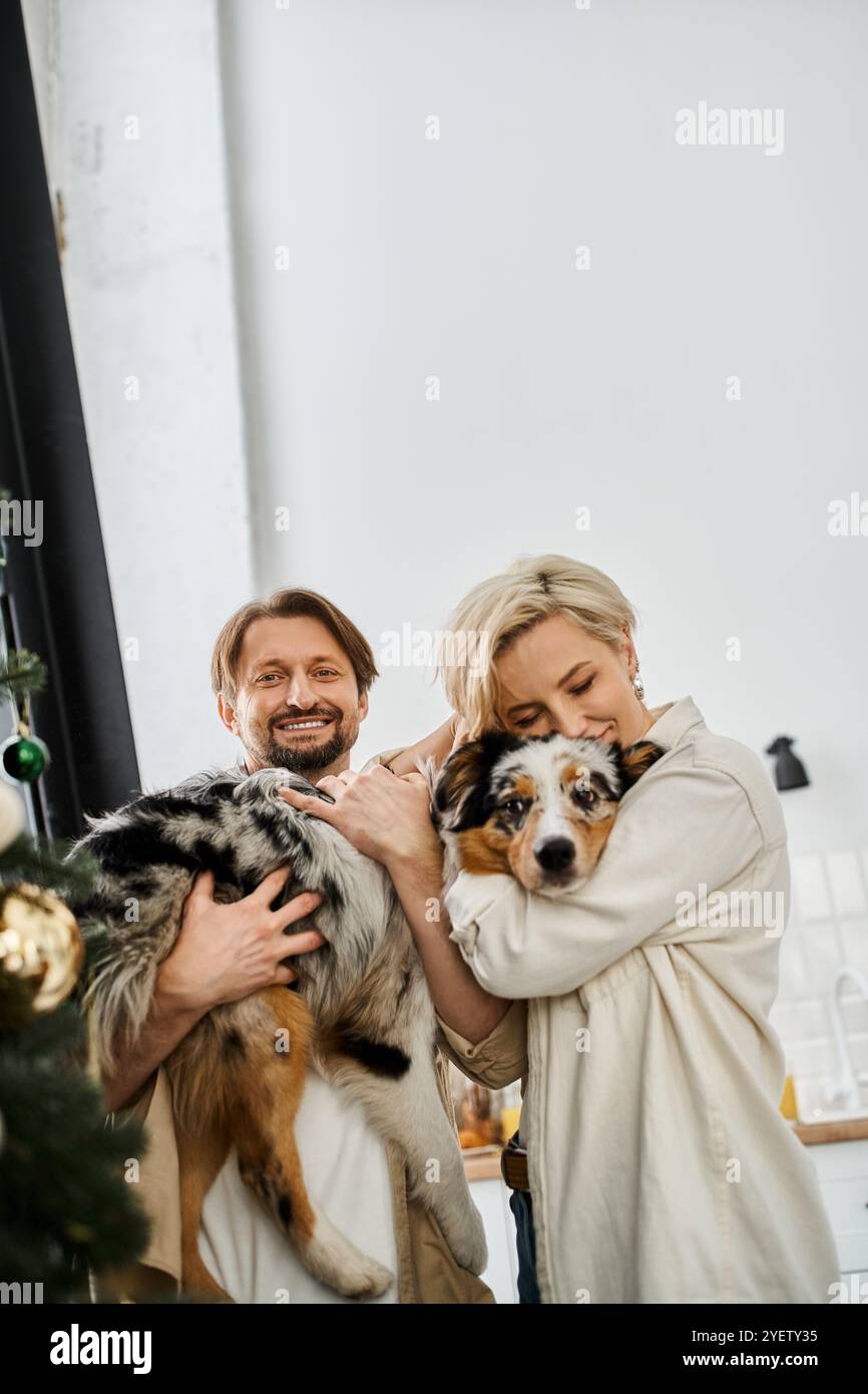 Una coppia condivide un momento tenero mentre coccola il suo amato animale domestico nel comfort di casa. Foto Stock