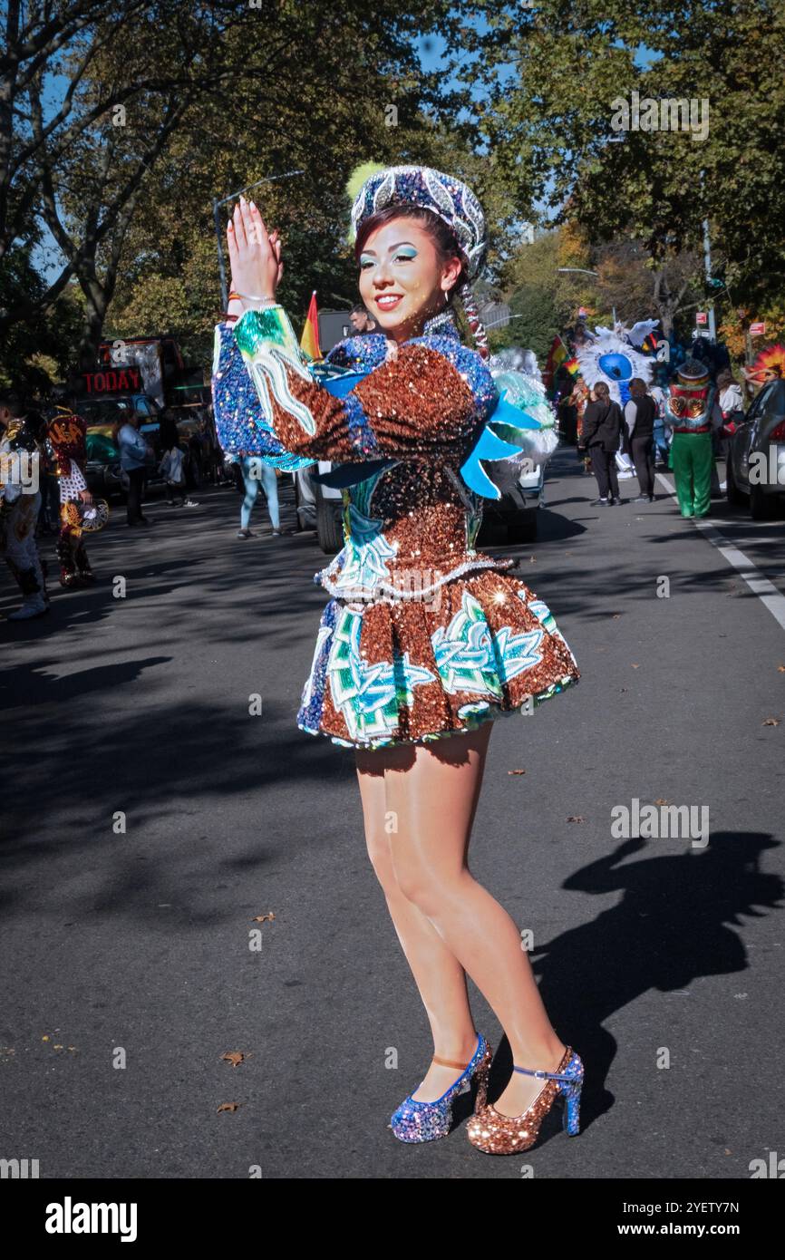 Una giovane signora del gruppo di danza San Simon rompe alcune mosse prima della sfilata di Jackson Heights, Queens, New York Foto Stock