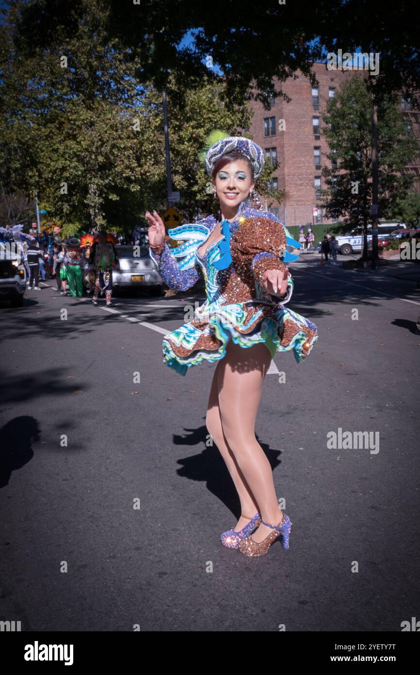 Una giovane signora del gruppo di danza San Simon rompe alcune mosse prima della sfilata di Jackson Heights, Queens, New York Foto Stock