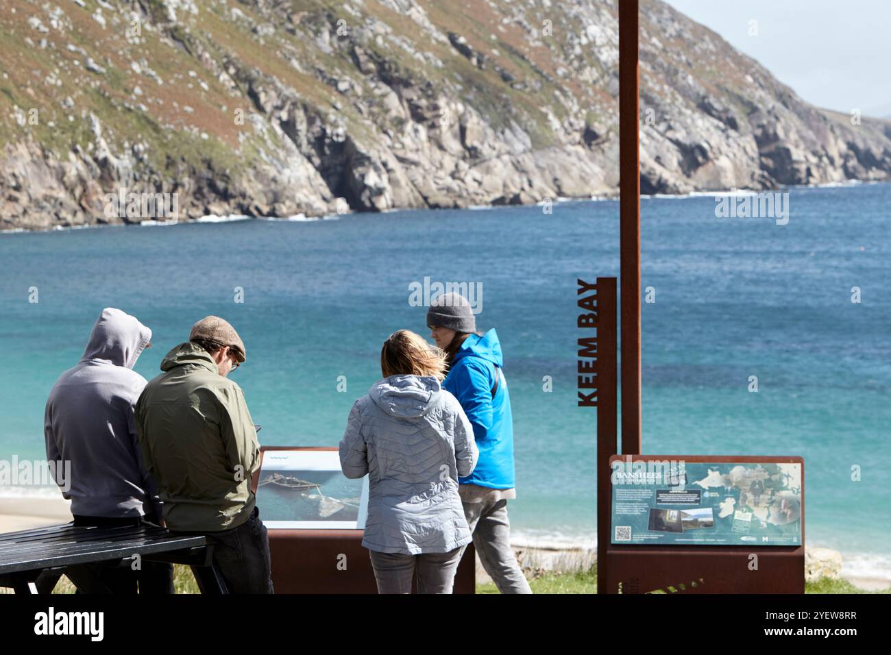 Turisti in una giornata ventosa al Wild atlantic Way Discovery Point e banshees of inisheerin Information Point keem Beach Achill Island, contea mayo, r Foto Stock