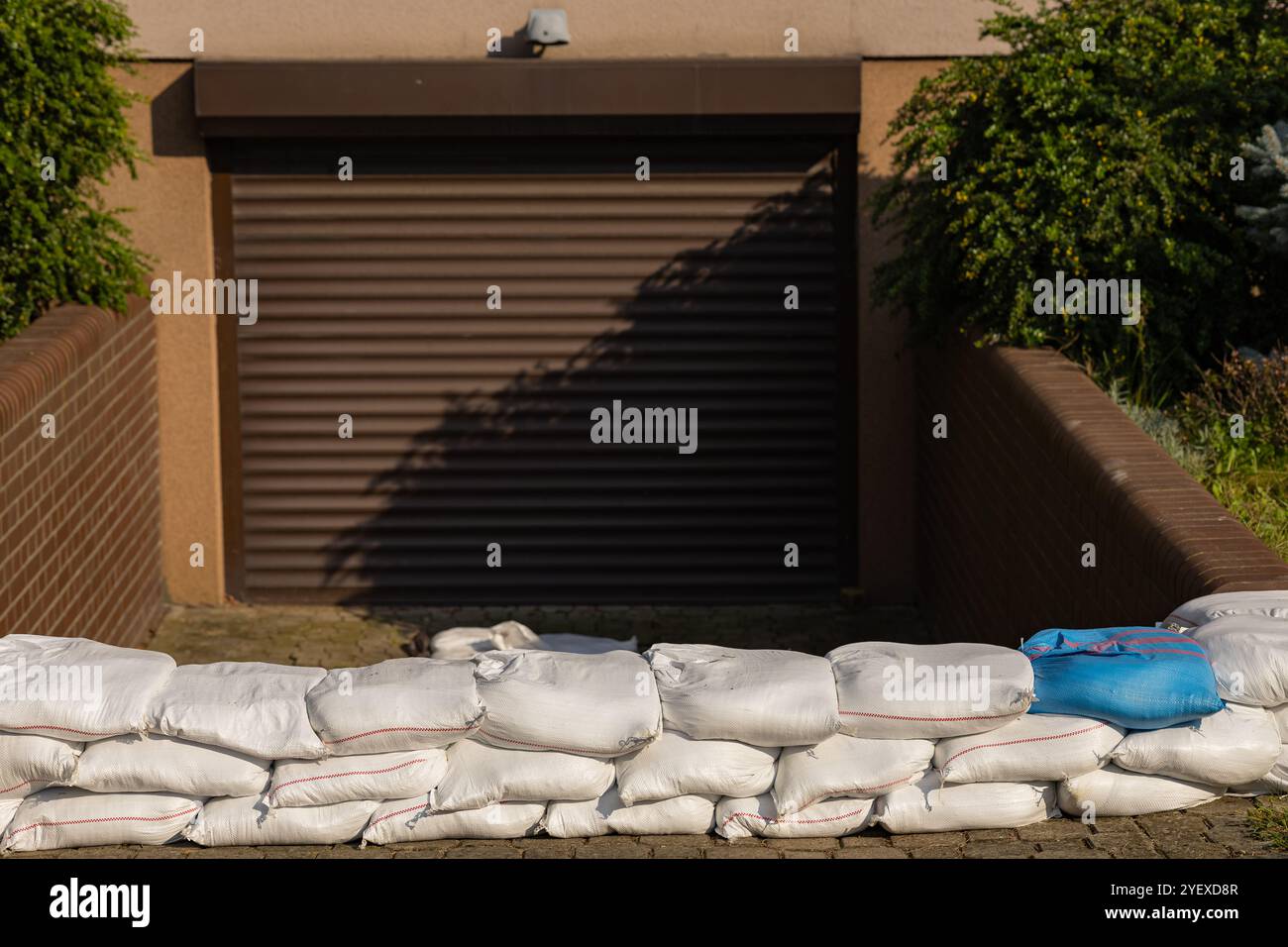 Sacchetti di sabbia impilati che fissano l'ingresso del garage contro potenziali danni causati dall'acqua durante la stagione delle alluvioni Foto Stock