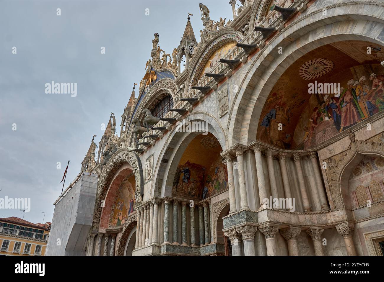Primo piano della facciata ornata della basilica di San Marco a Venezia. Questo iconico capolavoro bizantino presenta intricati mosaici d'oro, Foto Stock