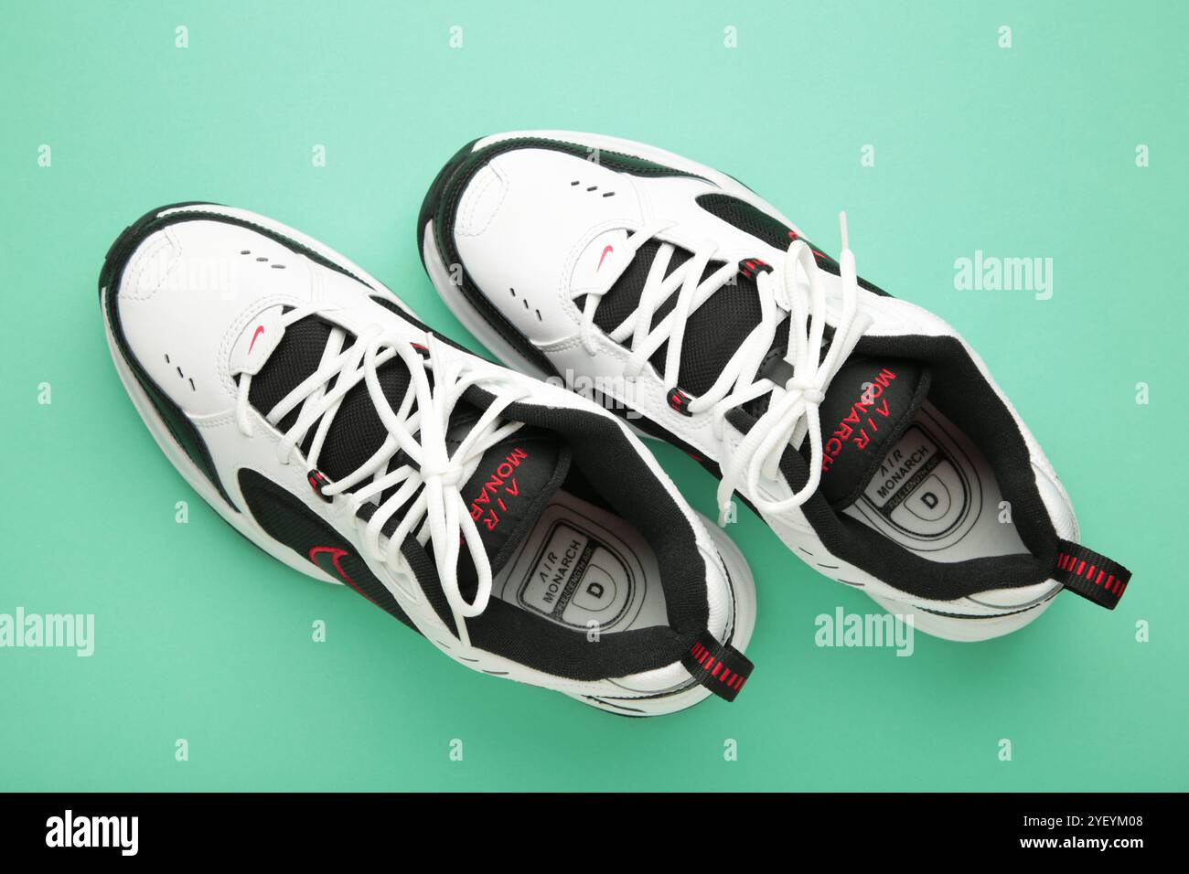 Mykolaiv, UCRAINA - luglio 2024. NIKE AIR MONARCH. Scarpe sportive da donna su sfondo di menta. Foto Stock