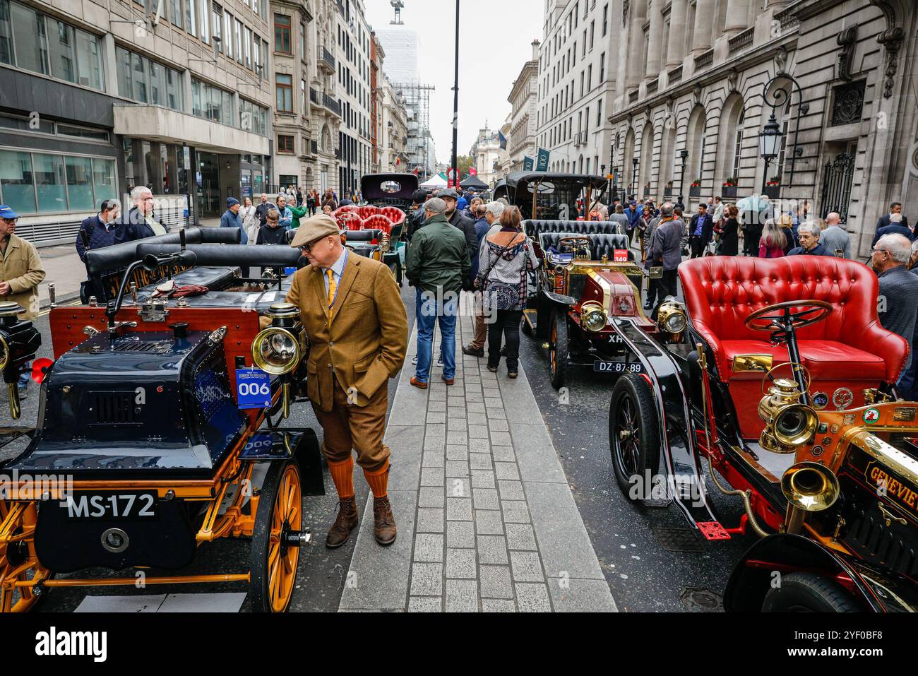 Londra, Regno Unito. 2 novembre 2024. Il proprietario di una Daimler del 1897 controlla l'auto mentre i visitatori camminano lungo le auto veterane splendidamente allineate. Lo spettacolo automobilistico di St James è promosso come il più grande salone automobilistico di Londra, che celebra il meglio del passato, del presente e del futuro dell'automobilismo. Molti dei modelli di auto d'epoca prendono parte anche al ralley di domani. Crediti: Imageplotter/Alamy Live News Foto Stock