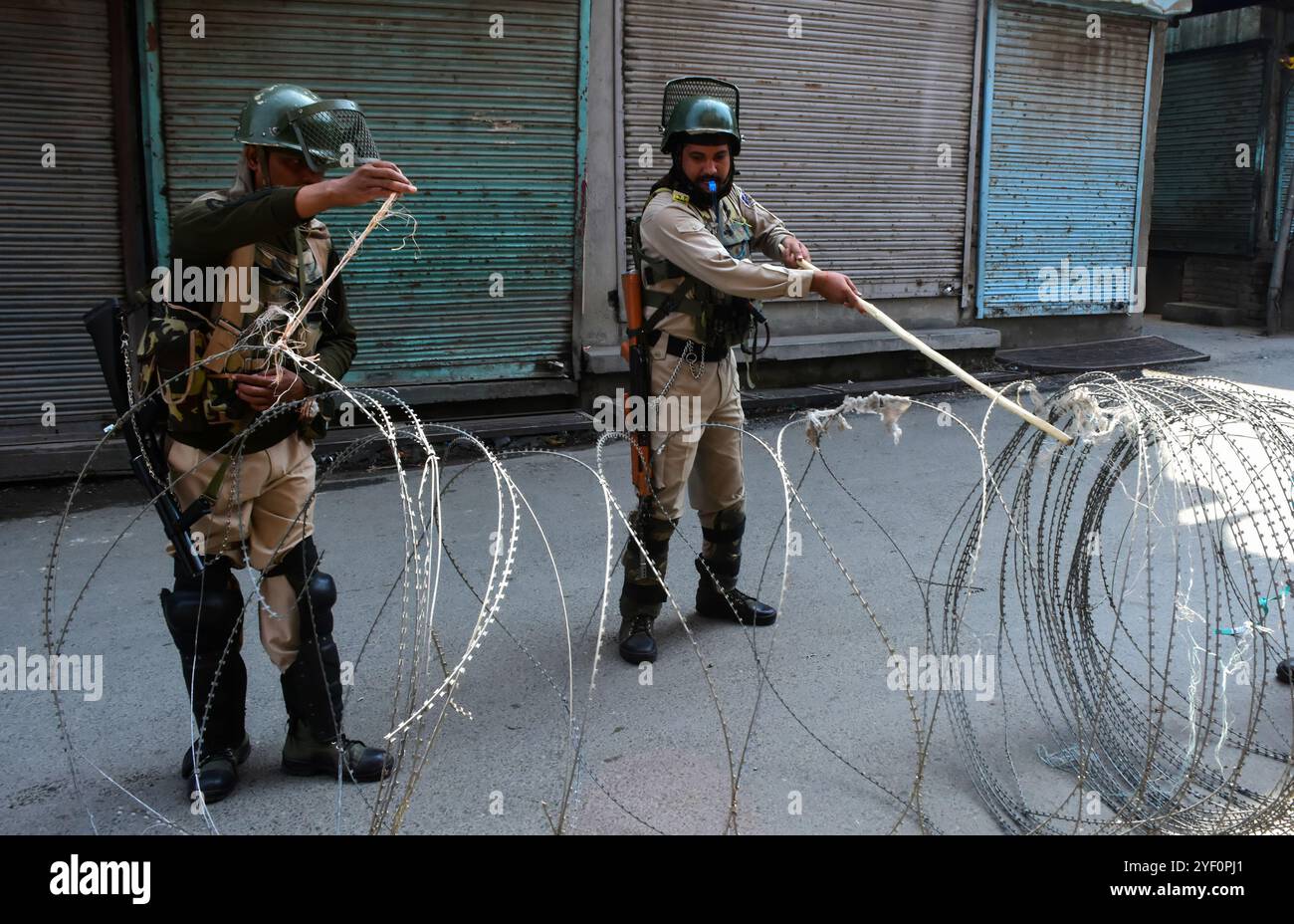 Le forze indiane sono in allerta mentre alcuni poliziotti posano bobine di filo di rasoio come il coprifuoco è imposto a Srinagar, nel Kashmir amministrato dall'India il 17 settembre 2018. Nella valle del Kashmir è in corso il coprifuoco dopo un appello dei leader della resistenza congiunta (JRL) a osservare un arresto completo a seguito delle recenti uccisioni di 5 ribelli e 1 civile che hanno avuto luogo nella città di Qazigund nel distretto di Kulgam nello stato indiano di Jammu e Kashmir Foto Stock