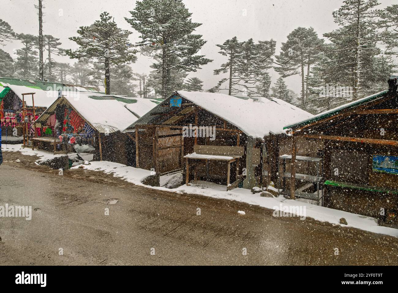 Coperte di neve cabine lungo la strada durante il viaggio panoramico a Zero Point nel Sikkim, India, in un tranquillo ambiente invernale. Foto Stock