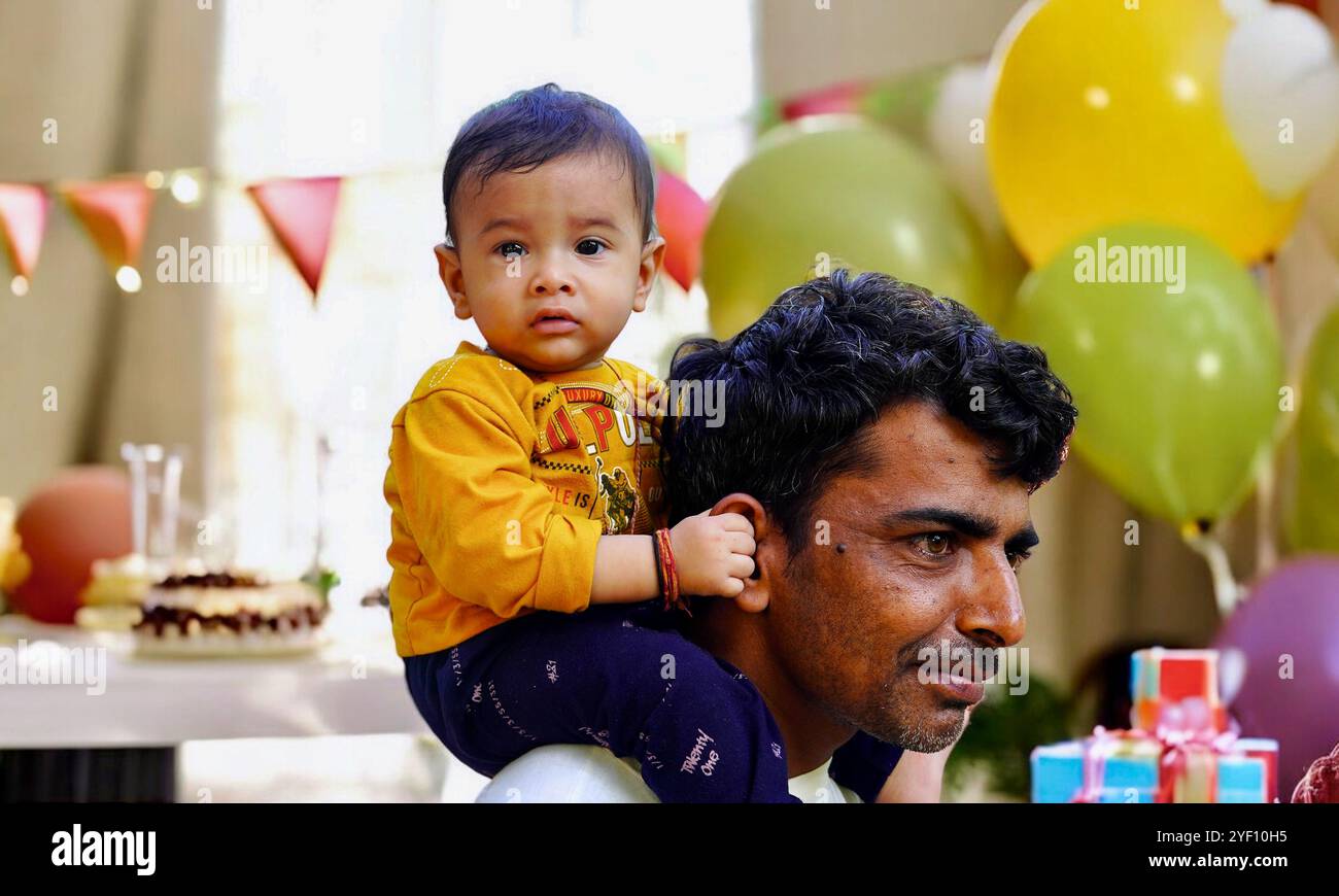 Padre maturo che fa un giro in piggyback a un figlio piccolo sullo sfondo dello studio. Festa dei padri. Ritratto di un figlio felice sorridente seduto sulle spalle dei padri e l Foto Stock