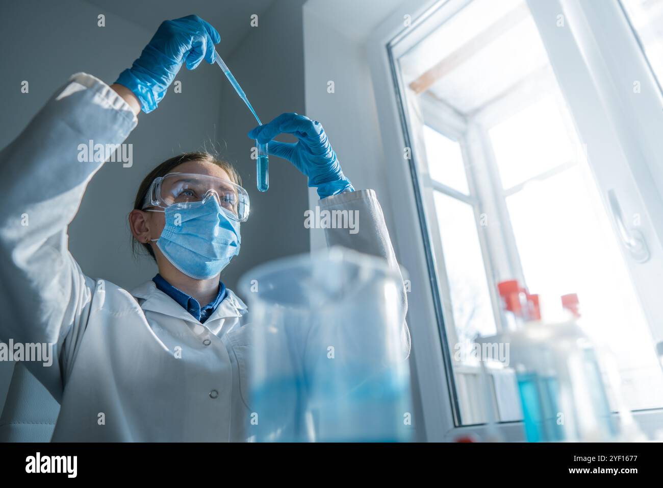 Uno scienziato dedicato sta conducendo un esperimento all'interno di un laboratorio ben attrezzato, utilizzando strumenti di precisione e strumenti high-tech per Foto Stock