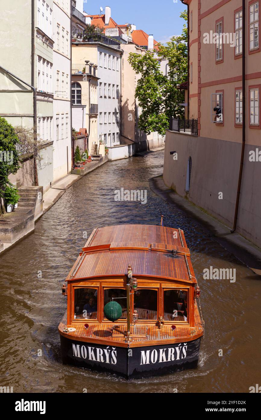 Taxi-boat sul pittoresco canale Čertovka (Canale del Diavolo), un corso d'acqua che separa Kampa da Mala strana nella città vecchia di Praga, Repubblica Ceca. Foto Stock