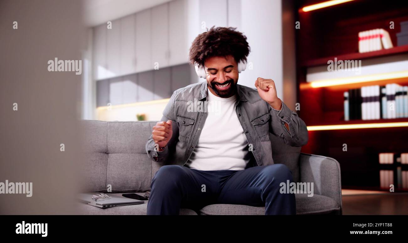 Uomo afroamericano sorridente che ascolta musica sulle cuffie Foto Stock
