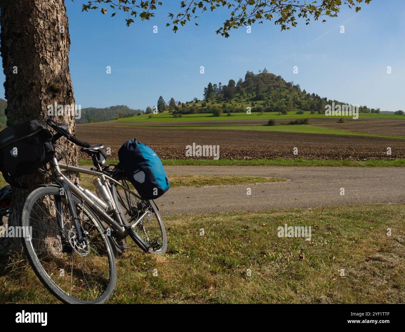 Burladingen, Germania - 2 ottobre 2023: Una bici da turismo di fronte alla collina di Kornbuehl con la chiesa di Sant'Anna Foto Stock
