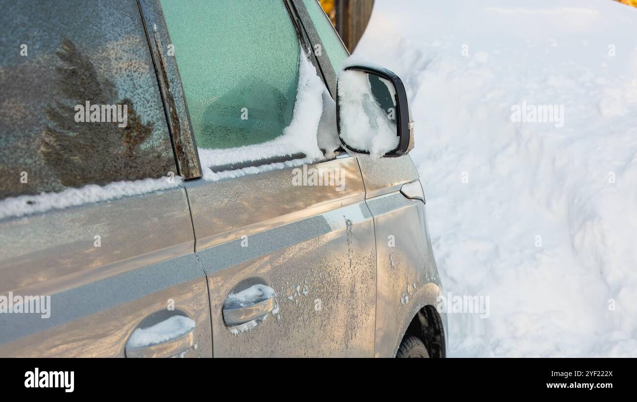 Specchio laterale e finestrino innevati, primo piano. Foto Stock