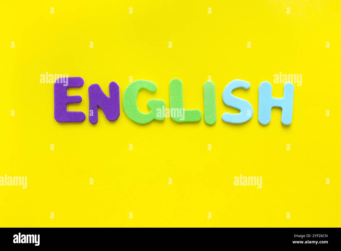 Parola INGLESE realizzata con lettere colorate su sfondo giallo con spazio di copia. Concetto di corsi di lingua inglese. Foto Stock
