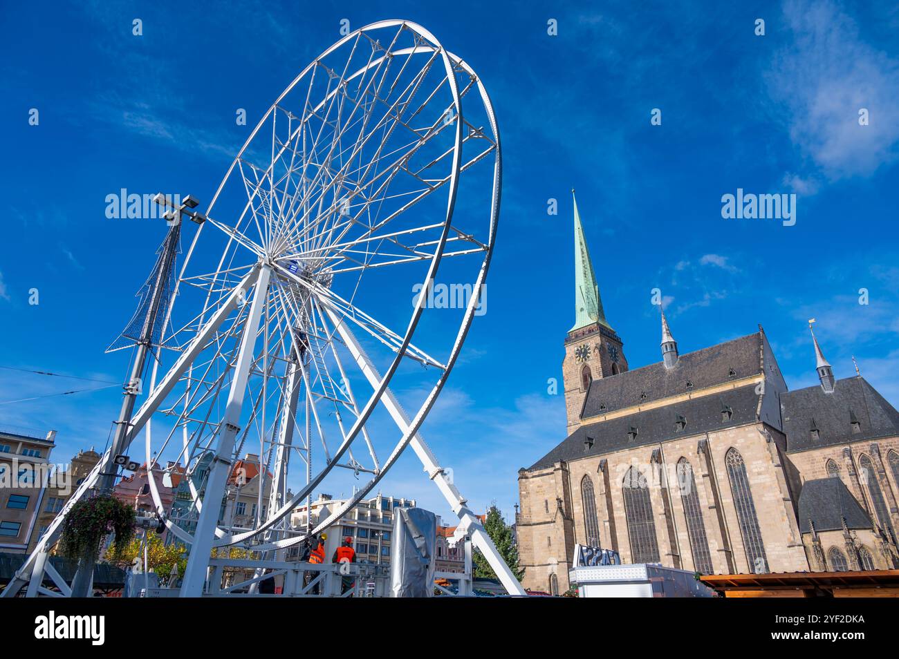 Una splendida vista della ruota panoramica nella piazza di fronte alla cattedrale di San Bartolomeo a Pilsen, adornata di luci festive durante il Natale Foto Stock