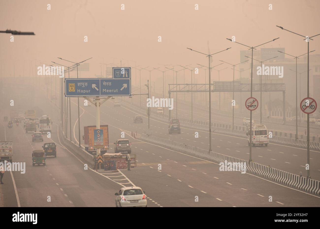 GHAZIABAD, INDIA - 2 NOVEMBRE: I veicoli si spostano su una strada della Delhi Meerut Expressway in mezzo alla bassa visibilità dovuta allo smog un giorno dopo le celebrazioni del festival diwali a Ghaziabad la mattina presto NH9 Lal kuan, il 2 novembre 2024 a Ghaziabad, India. L'NCR di Delhi ha visto un forte aumento dei livelli di inquinamento dopo Diwali, nonostante il divieto di attaccare i pirati. La qualità dell'aria si è rapidamente deteriorata, con Delhi classificata come "molto povera". Città come Gurugram, Ghaziabad e Noida devono affrontare condizioni "molto povere". Le strade ricoperte di resti di firecacker e schiuma tossica sul fiume Yamuna aumentano i rischi per la salute. Credito Foto Stock